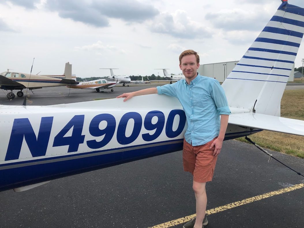Christopher Aselin, certified flight instructor, standing beside a single-engine airplane