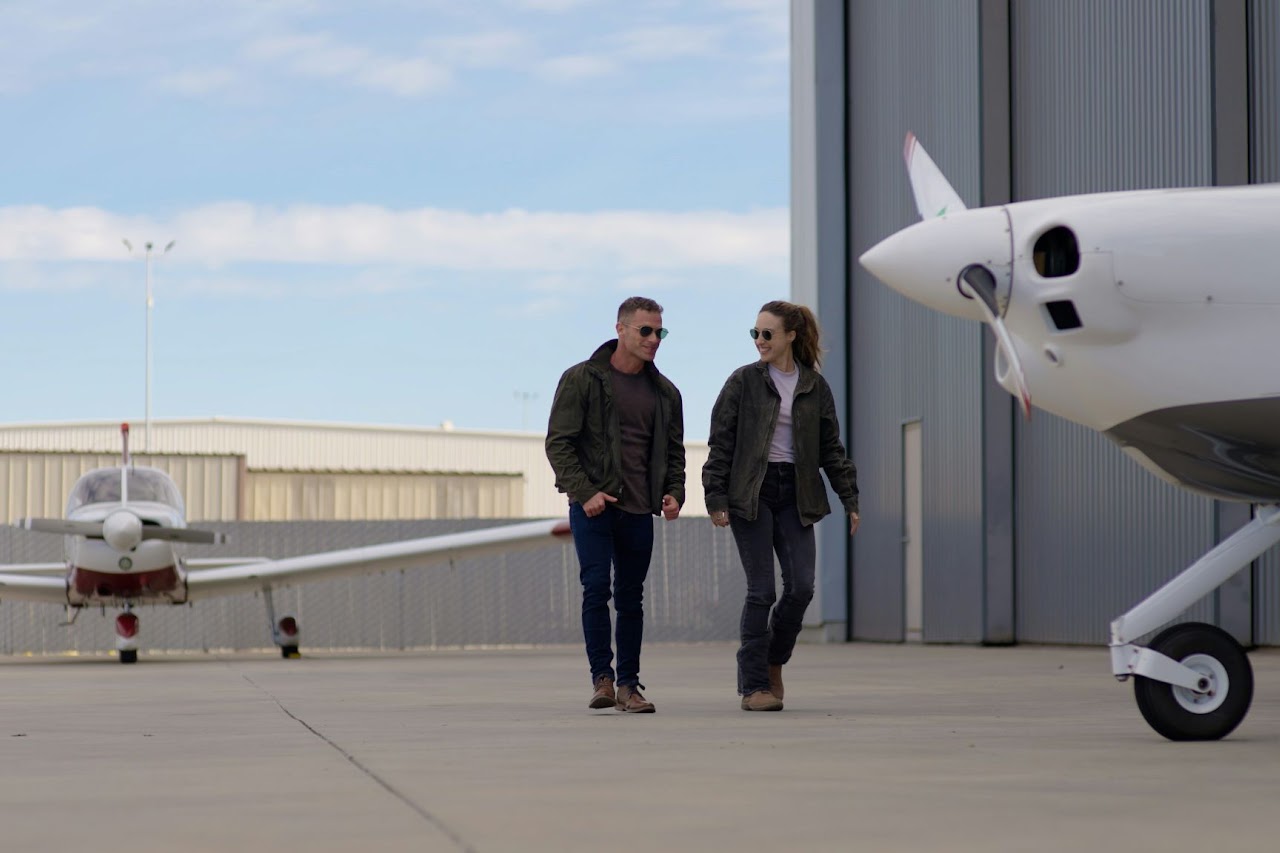 People walking between general aviation aircraft on an airport ramp