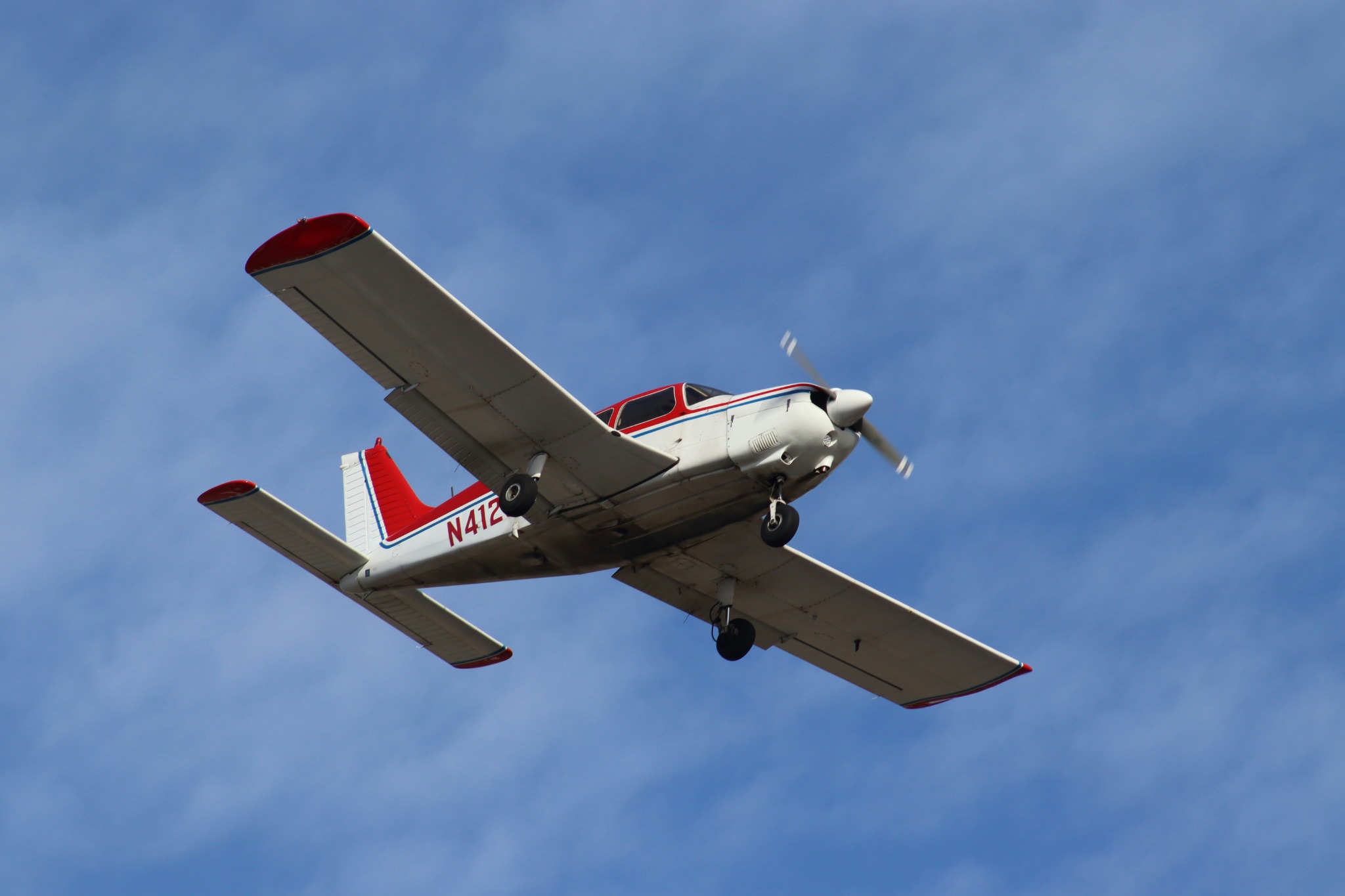 Red and white general aviation airplane in flight